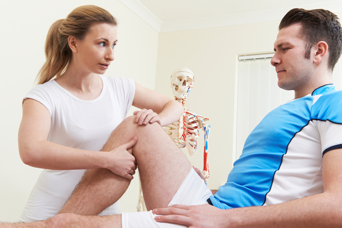 An orthopedic physician’s assistant assesses a male athlete with a possible patellofemoral pain syndrome diagnosis.