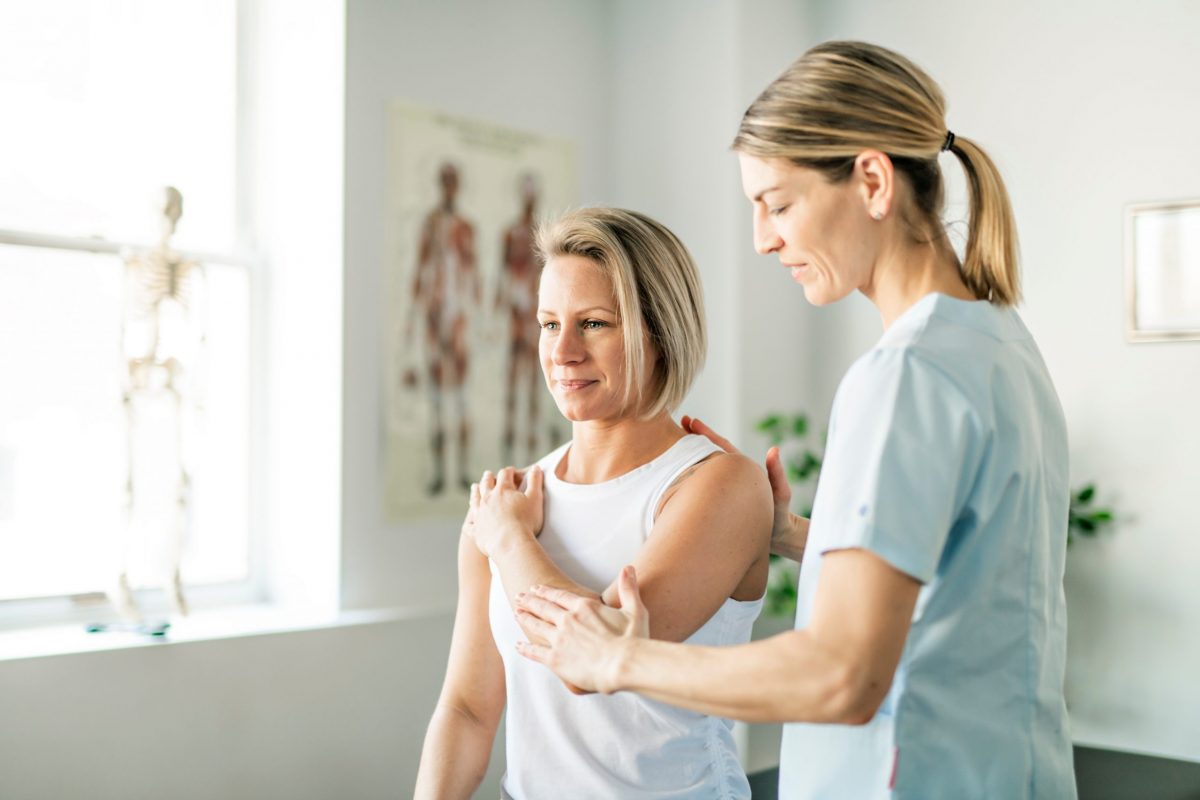 A female orthopedic doctor evaluates a female patient to see if trigger point injections will help her shoulder pain.