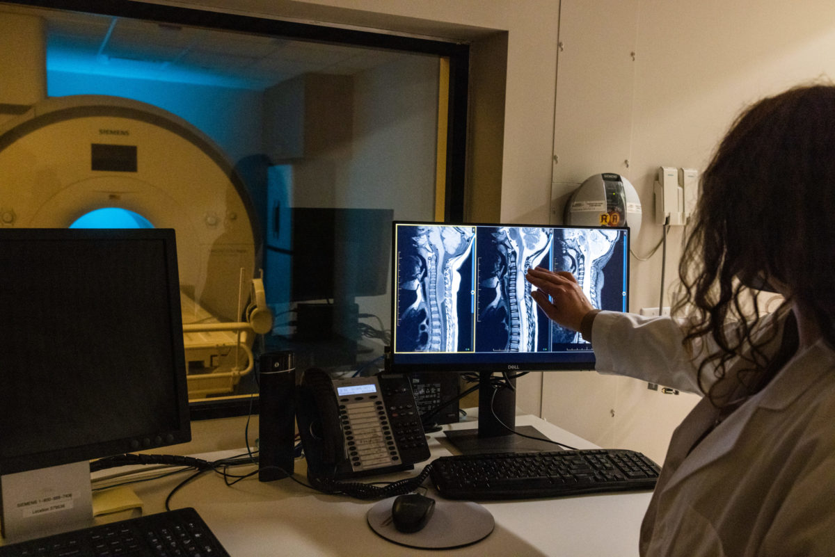 An EmergeOrtho—Triangle Region provider reviews MRI images of a spine. 