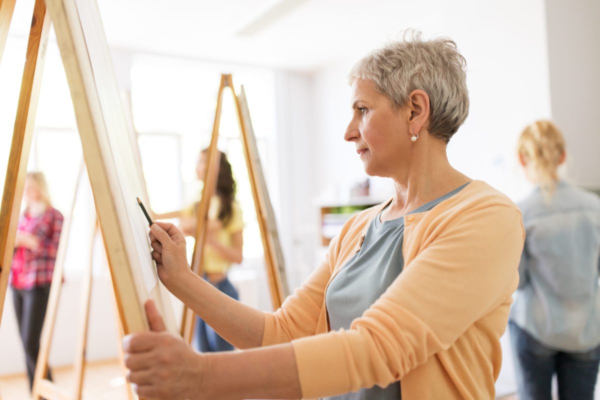 Senior woman enjoy quality of life at a group painting class. 