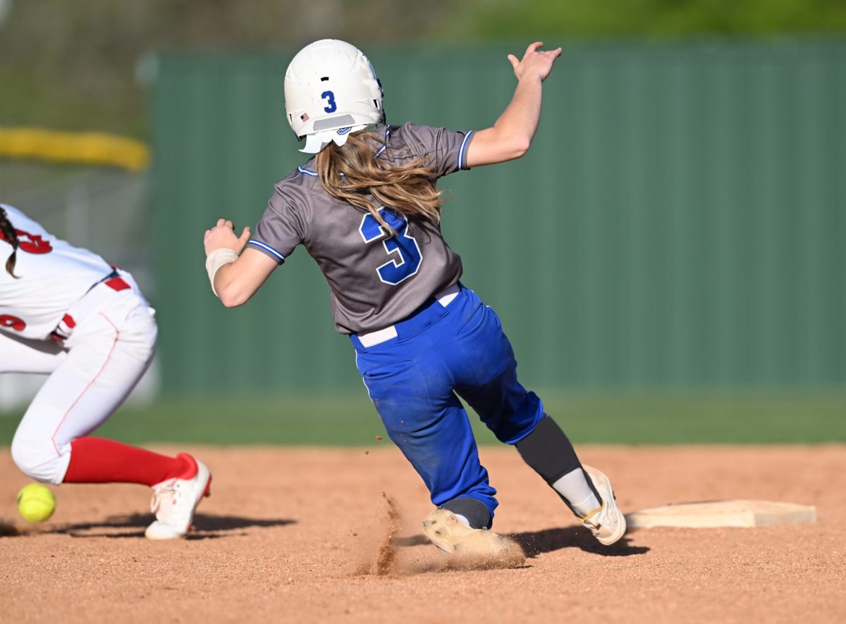  Image of a young girl running toward base in softball game 