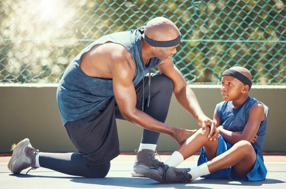  A coach tends to his young athlete experiencing one of many youth sports injuries. 