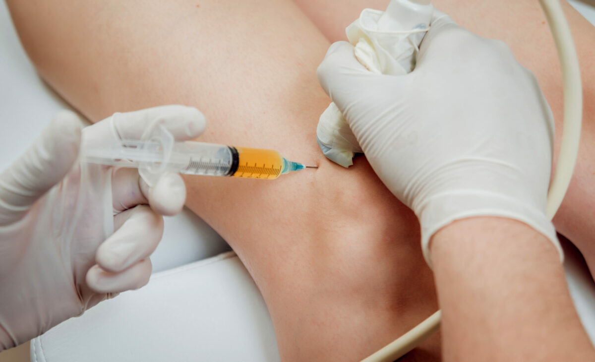Orthopedist injecting medicine into a patient’s knee.