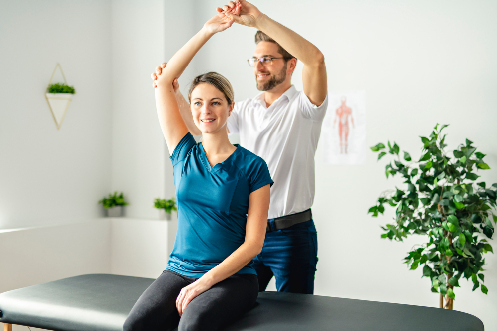  A physical therapist stretches the arm of a patient. 